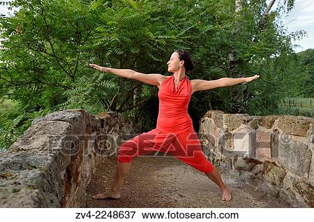 Stock Photo - "Middle aged woman doing yoga in a park in summer, Germany. ". Fotosearch