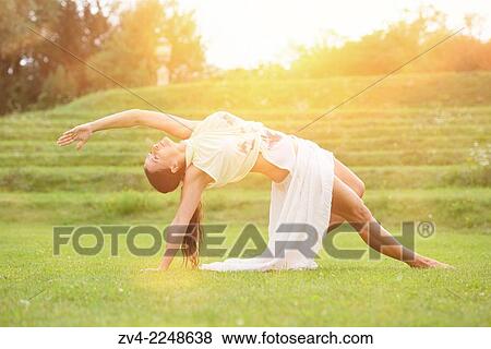 Stock Photo - "Middle aged woman doing yoga in a park in summer, Germany. ". Fotosearch
