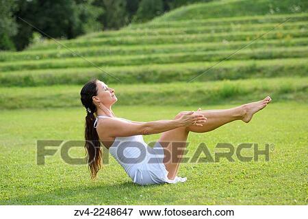 Stock Photo - "Middle aged woman doing yoga in a park in summer, Germany. ". Fotosearch