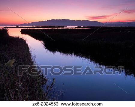Stock Image - "Montsia Hills at dusk and Encanyissada Lagoon. Ebro River Delta Natural Park, Tarragona province, Catalonia, Spain. ". Fotosearch