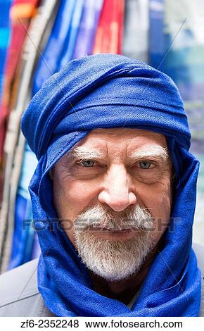 Stock Photo - Morocco Fez silk factory tourist man wearing blue silk turbin in store.. Fotosearch