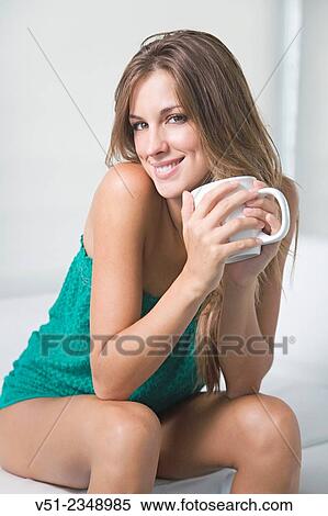 Portrait of a blonde woman at home with a cup of coffee smiling at camera in the living room View Large Photo Image Stock Photography - Portrait of a blonde woman at home with a cup of coffee smiling at camera in the living room. Fotosearch