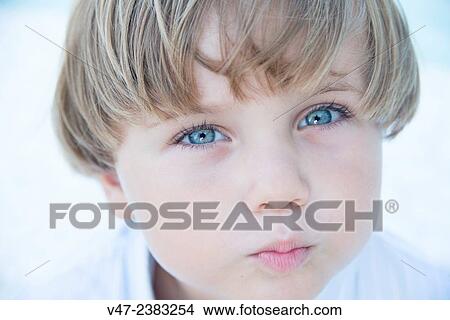 Picture - Portrait of a boy with blue eyes giving an air kiss. Fotosearch