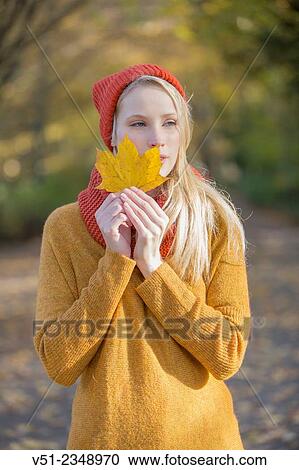Portrait of a pretty blonde woman in park in autumn with leaf covering partially her face View Large Photo Image Stock Image - Portrait of a pretty blonde woman in park in autumn with leaf covering partially her face. Fotosearch