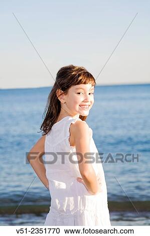 Portrait of a young girl at the beach smiling at camera View Large Photo Image Stock Image - Portrait of a young girl at the beach smiling at camera. Fotosearch