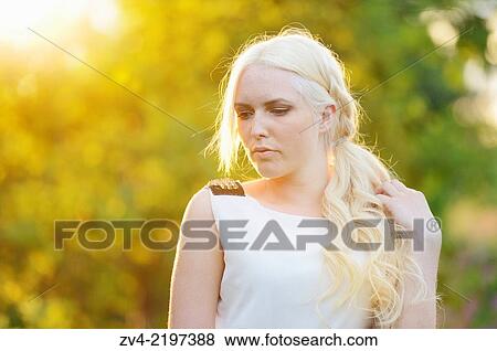 Stock Photo - Portrait of a young woman at sunset.. Fotosearch