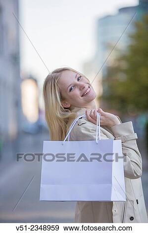 Pretty blonde woman happy with her shopping bag View Large Photo Image Stock Photo - Pretty blonde woman happy with her shopping bag. Fotosearch