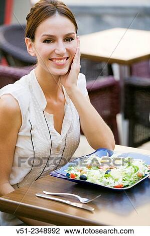 Pretty woman enjoying a salad in a restaurant outdoors smiling at camera View Large Photo Image Stock Image - Pretty woman enjoying a salad in a restaurant outdoors smiling at camera. Fotosearch