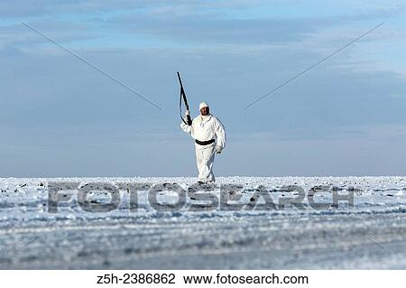 Stock Image - Russian Federation. Voronezh oblvst. Hunter in camouflage white suit on winter hunting.. Fotosearch