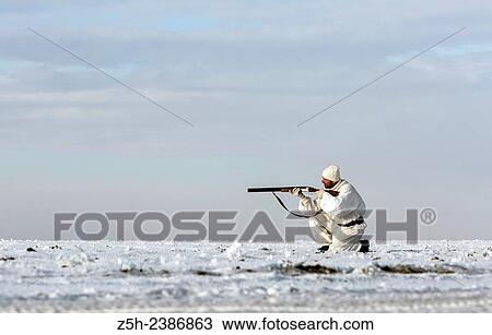 Stock Image - Russian Federation. Voronezh oblvst. Hunter in camouflage white suit on winter hunting.. Fotosearch