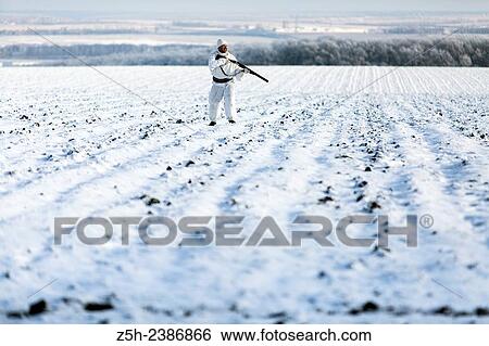 Stock Photograph - Russian Federation. Voronezh oblvst. Hunter in camouflage white suit on winter hunting.. Fotosearch