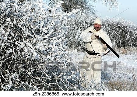 Stock Photography - Russian Federation. Voronezh oblvst. Hunter in camouflage white suit on winter hunting.. Fotosearch