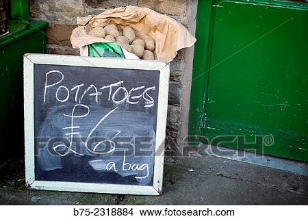 "Sack of potatoes in front of a grocery store with a blackboard that says: Potatoes 6 pounds a bag. Howes, Yorkshire Dales, England, UK, Europe" View Large Photo Image Picture - "Sack of potatoes in front of a grocery store with a blackboard that says: Potatoes 6 pounds a bag. Howes, Yorkshire Dales, England, UK, Europe". Fotosearch