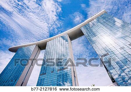 "Singapore, worm´s eye view of the bold architecture of the Marina Bay Sands Hotel and skypark complex, the three 200 metre hotel towers are conected at the top by 9941 square metres skypark bridge. " View Large Photo Image Stock Photograph - "Singapore, worm´s eye view of the bold architecture of the Marina Bay Sands Hotel and skypark complex, the three 200 metre hotel towers are conected at the top by 9941 square metres skypark bridge. ". Fotosearch
