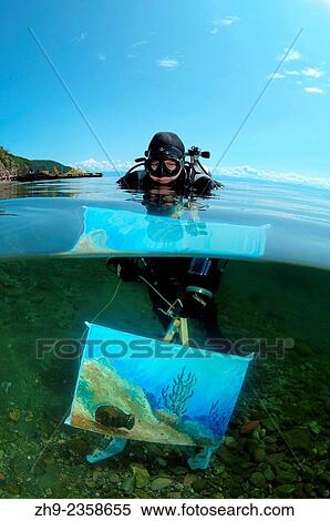 "The assistant shows a picture of the artist written by under water artist Yuriy Alexeev (Yuri Alekseev). Lake Baikal, Listvyanka, Irkutsky District, Irkutsk Oblast, Siberia, Russia, Eurasia. " View Large Photo Image Stock Photography - "The assistant shows a picture of the artist written by under water artist Yuriy Alexeev (Yuri Alekseev). Lake Baikal, Listvyanka, Irkutsky District, Irkutsk Oblast, Siberia, Russia, Eurasia. ". Fotosearch