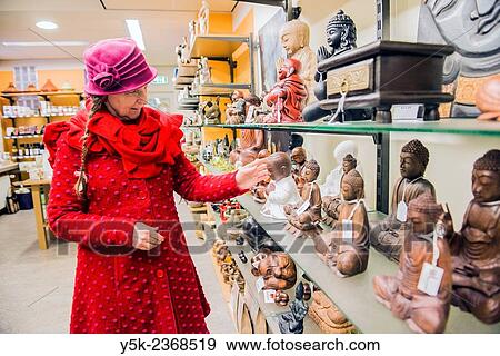 Stock Photo - "Tilburg, Netherlands. A 61 year old colorful dressed and fashionable woman shopping in a local fair trade store. ". Fotosearch
