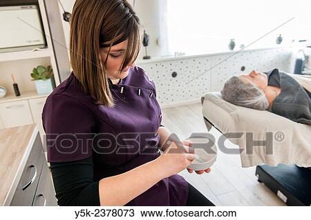 Stock Image - "Tilburg, Netherlands. Female beautician and her new customer preparing for a session in her beauty salon. ". Fotosearch