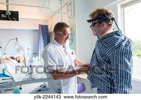 "Tilburg, Netherlands. Male nurse at an orthopedics nursing ward helping a patient with head brace after a fractured cervical. " View Large Photo Image Stock Image - "Tilburg, Netherlands. Male nurse at an orthopedics nursing ward helping a patient with head brace after a fractured cervical. ". Fotosearch