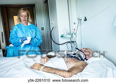 "Tilburg, Netherlands. Male orthopedic patient, recovering in a hospital sand bed to prevent decubitus, is nursed by a female nurse, wearing protective clothing against bacterial infection. " View Large Photo Image Stock Image - "Tilburg, Netherlands. Male orthopedic patient, recovering in a hospital sand bed to prevent decubitus, is nursed by a female nurse, wearing protective clothing against bacterial infection. ". Fotosearch