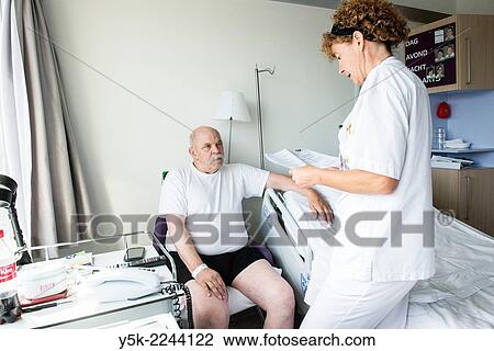 "Tilburg, Netherlands. Physio therapist instructing a male post operative patient on how to walk again, after reviving a new hip in surgery. " View Large Photo Image Stock Image - "Tilburg, Netherlands. Physio therapist instructing a male post operative patient on how to walk again, after reviving a new hip in surgery. ". Fotosearch