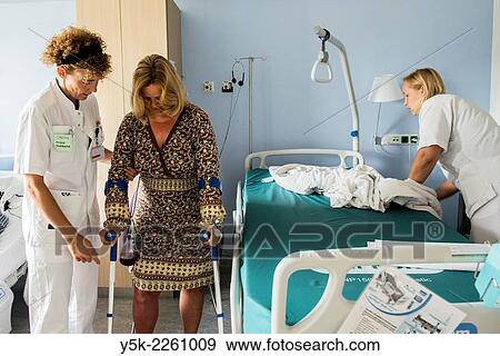 "Tilburg, Netherlands. Physio therapist instructing a female post operative patient on how to walk again, after reviving a new hip in surgery. " View Large Photo Image Stock Photo - "Tilburg, Netherlands. Physio therapist instructing a female post operative patient on how to walk again, after reviving a new hip in surgery. ". Fotosearch
