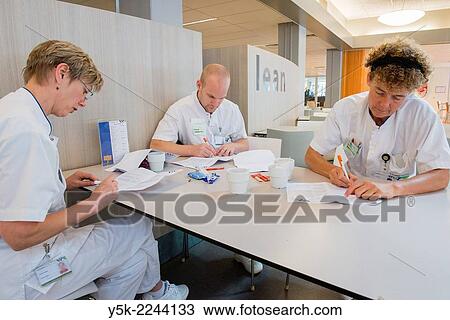 "Tilburg, Netherlands. Three Physio therapists working on their planning for the treatment of hospital patients, while being on their coffee brake. " View Large Photo Image Stock Image - "Tilburg, Netherlands. Three Physio therapists working on their planning for the treatment of hospital patients, while being on their coffee brake. ". Fotosearch