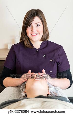 "Tilburg, Netherlands. Young beautician applying a massage to the facial skin of her customer. " View Large Photo Image Picture - "Tilburg, Netherlands. Young beautician applying a massage to the facial skin of her customer. ". Fotosearch