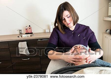 "Tilburg, Netherlands. Young beautician applying a massage to the facial skin of her customer. " View Large Photo Image Stock Image - "Tilburg, Netherlands. Young beautician applying a massage to the facial skin of her customer. ". Fotosearch