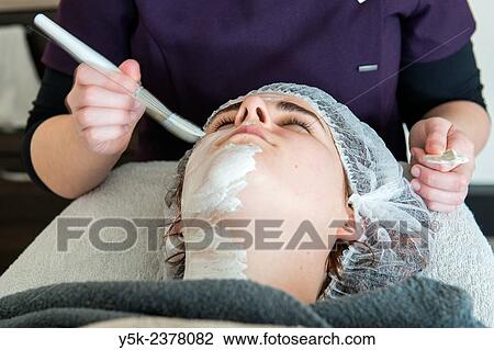 "Tilburg, Netherlands. Young beautician applying cleansing cream to the facial skin of her customer. " View Large Photo Image Stock Image - "Tilburg, Netherlands. Young beautician applying cleansing cream to the facial skin of her customer. ". Fotosearch