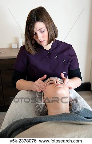 "Tilburg, Netherlands. Young beautician applying a massage to the facial skin of her customer. " View Large Photo Image Stock Photograph - "Tilburg, Netherlands. Young beautician applying a massage to the facial skin of her customer. ". Fotosearch