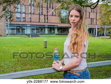 "Tilburg, Netherlands. Young, brunette woman, holding a bottle of water in a park. " View Large Photo Image Stock Photo - "Tilburg, Netherlands. Young, brunette woman, holding a bottle of water in a park. ". Fotosearch