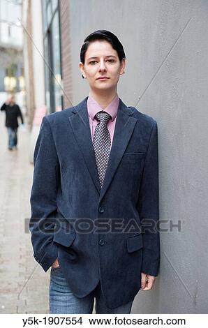 "Tilburg, Netherlands. Young woman, dressed up as a man, standing in front of a concrete wall near main street. " View Large Photo Image Picture - "Tilburg, Netherlands. Young woman, dressed up as a man, standing in front of a concrete wall near main street. ". Fotosearch