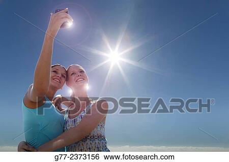 Stock Photograph - "Two young women taking selfie. Miami Beach, Florida, Usa. ". Fotosearch