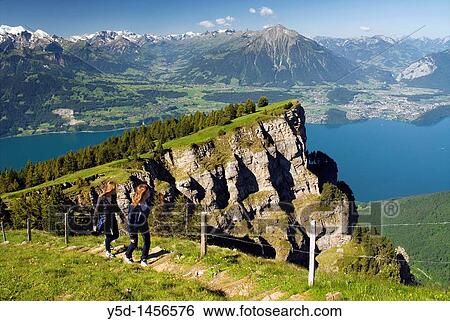 "two young women walking in Swiss Alps, Niederhorn, canton Bern, Switzerland" View Large Photo Image Stock Photograph - "two young women walking in Swiss Alps, Niederhorn, canton Bern, Switzerland". Fotosearch