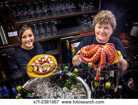 "Waitresses showing at right Octopus and at left ´Pulpo a feira´ octopus in Galician style, in Pulperia Melide, Plaza de España 16 or Plaza Campo de la Leña 16, Coruña city, Galicia, Spain. " View Large Photo Image Stock Photo - "Waitresses showing at right Octopus and at left ´Pulpo a feira´ octopus in Galician style, in Pulperia Melide, Plaza de España 16 or Plaza Campo de la Leña 16, Coruña city, Galicia, Spain. ". Fotosearch