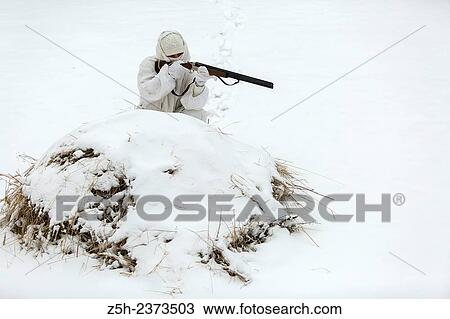 Stock Image - Winter hunting in white camouflage suit. Belgorod region.. Fotosearch