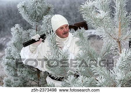 Stock Photo - Winter hunting in white camouflage suit. Belgorod region.. Fotosearch
