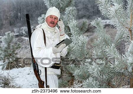 Stock Photograph - Winter hunting in white camouflage suit. Belgorod region.. Fotosearch