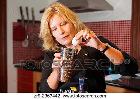 Stock Image - "Woman adding egg whites to a Pisco Sour, Chile´s national drink, Cooking class, Bellavista district, Santiago, Chile, South America. ". Fotosearch