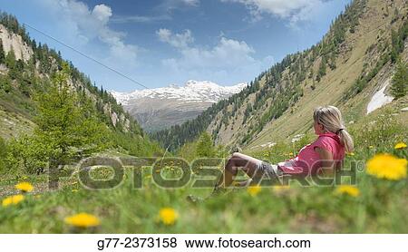 Stock Photo - "Woman in an alpine meadow, Canton of Graubünden, Switzerland". Fotosearch