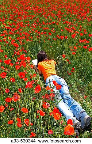 Woman lying on a poppies field View Large Photo Image Picture - Woman lying on a poppies field. Fotosearch