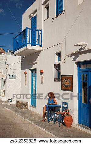 Stock Photograph - "Woman sitting in front of a house in Kamares, Sifnos, Cyclades Islands, Greek Islands, Greece, Europe. ". Fotosearch