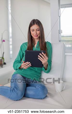 Woman using digital tablet on sofa View Large Photo Image Stock Image - Woman using digital tablet on sofa. Fotosearch