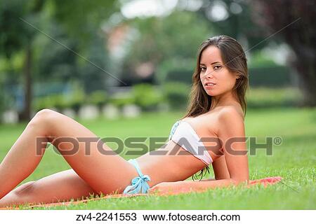 Young attractive woman with a bikini sitting on a meadow in an open-air bath. View Large Photo Image Stock Image - Young attractive woman with a bikini sitting on a meadow in an open-air bath.. Fotosearch
