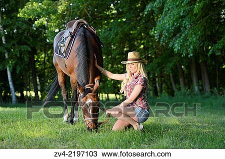 Young cowgirl beside a polish arabian horse on a meadow. View Large Photo Image Stock Image - Young cowgirl beside a polish arabian horse on a meadow.. Fotosearch