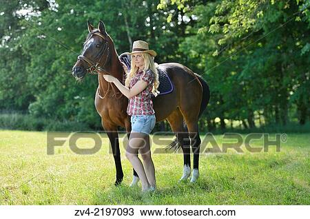Young cowgirl with a polish arabian horse standing on a meadow. View Large Photo Image Stock Image - Young cowgirl with a polish arabian horse standing on a meadow.. Fotosearch