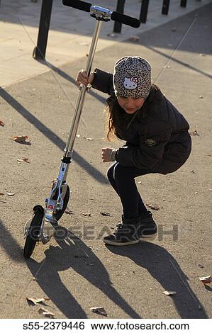 Stock Photograph - "Young girl with scooter. Barcelona, Catalonia, Spain". Fotosearch