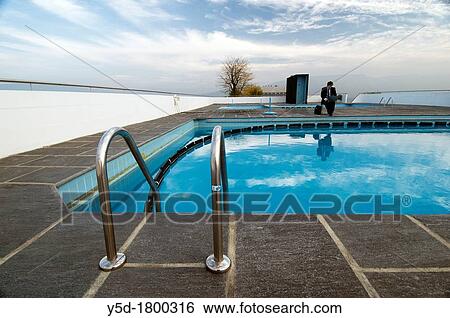 "young man studing, working with laptop close to empty, quiet swimming pool, Geneva, Switzerland" View Large Photo Image Stock Photograph - "young man studing, working with laptop close to empty, quiet swimming pool, Geneva, Switzerland". Fotosearch