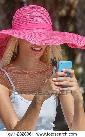 Stock Image - "Young woman on the beach with smart phone. Miami Beach, Florida, USA". Fotosearch