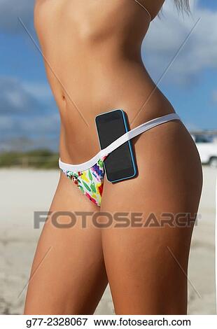 "Young woman on the beach with smartphone in the swimsuit. Miami Beach, Florida, USA" View Large Photo Image Stock Photo - "Young woman on the beach with smartphone in the swimsuit. Miami Beach, Florida, USA". Fotosearch